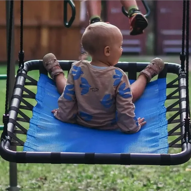 Kleinkind sitzt auf der blauen Platform Swing im Garten