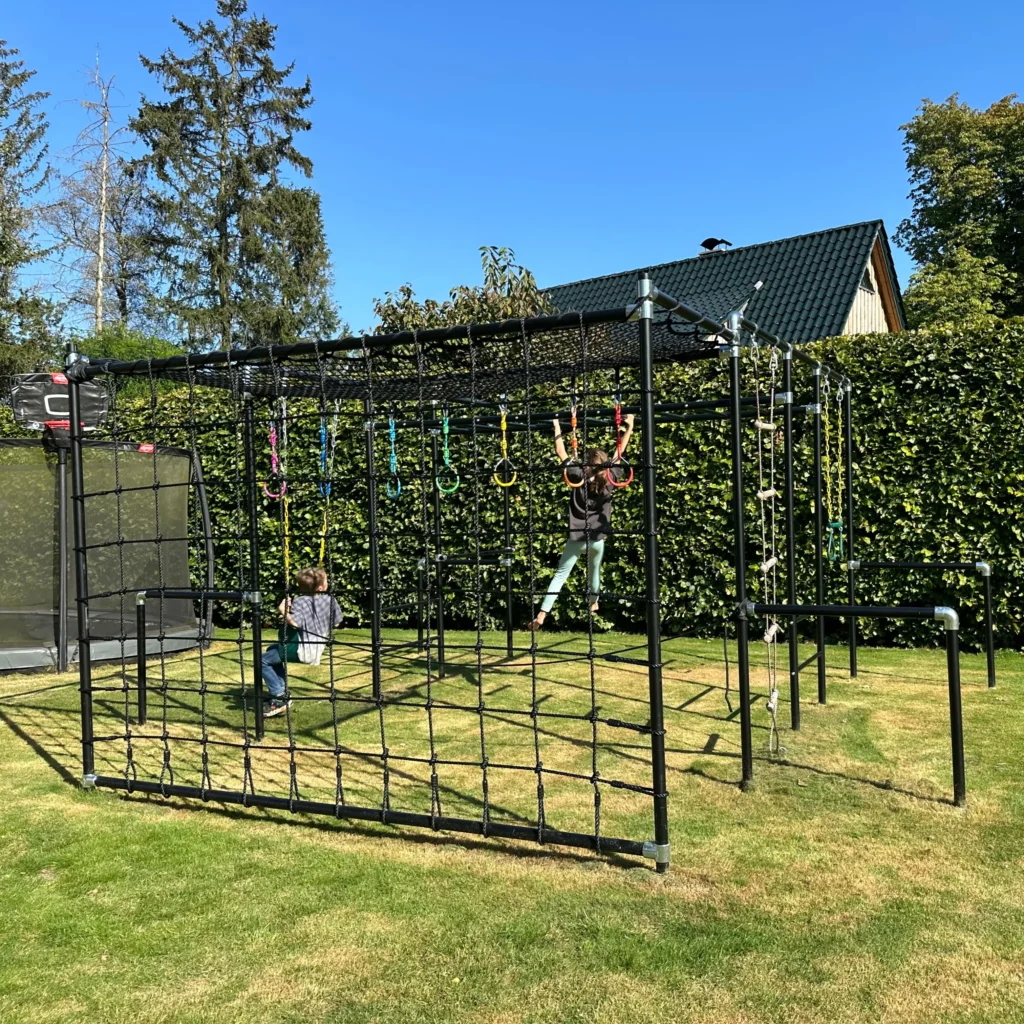Schwarzes Outdoor-Klettergerüst mit Turnringen im Garten aufgebaut