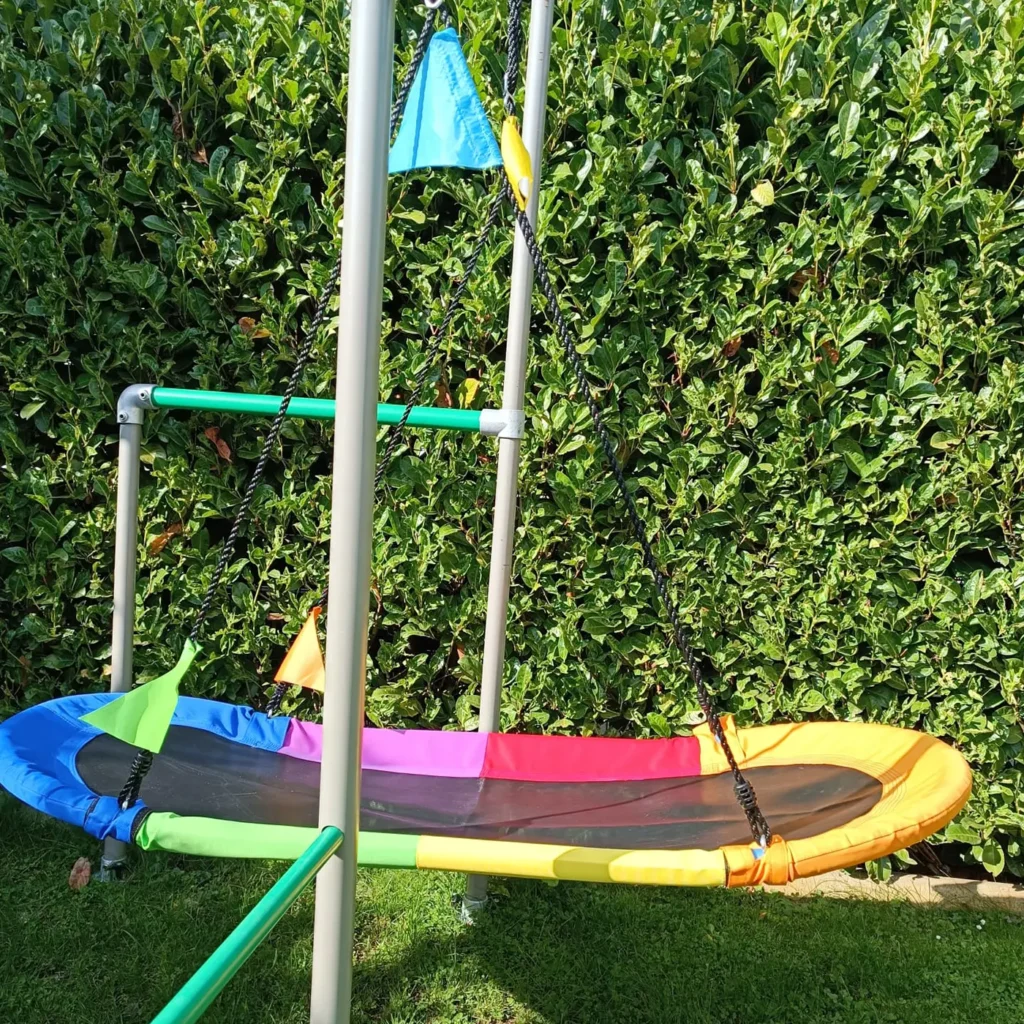Oval Swing Nestschaukel montiert am Spielturm im Garten, Seitenansicht