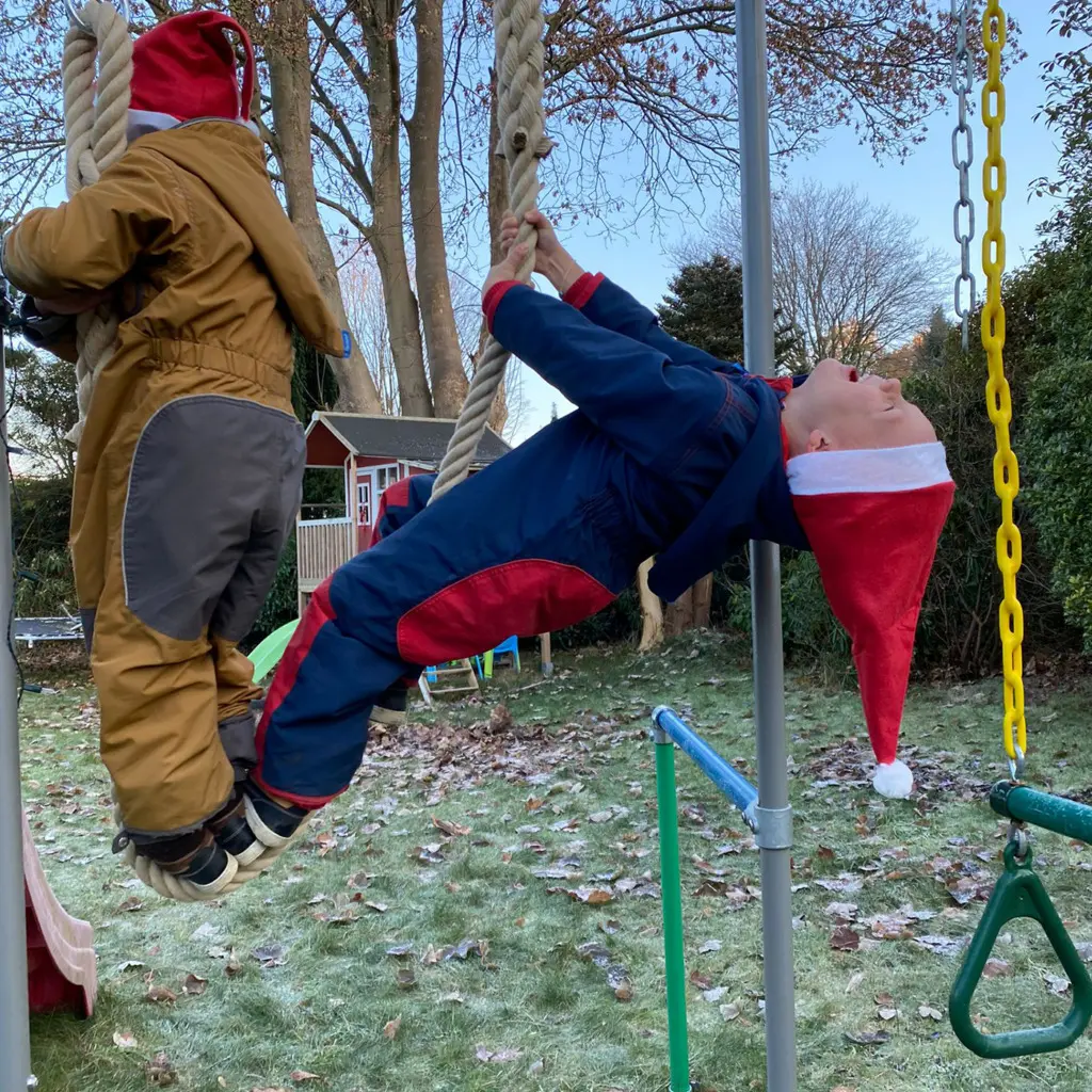 Kinder hängen kopfüber am 2 Meter Kletterseil, Wintertag im Garten