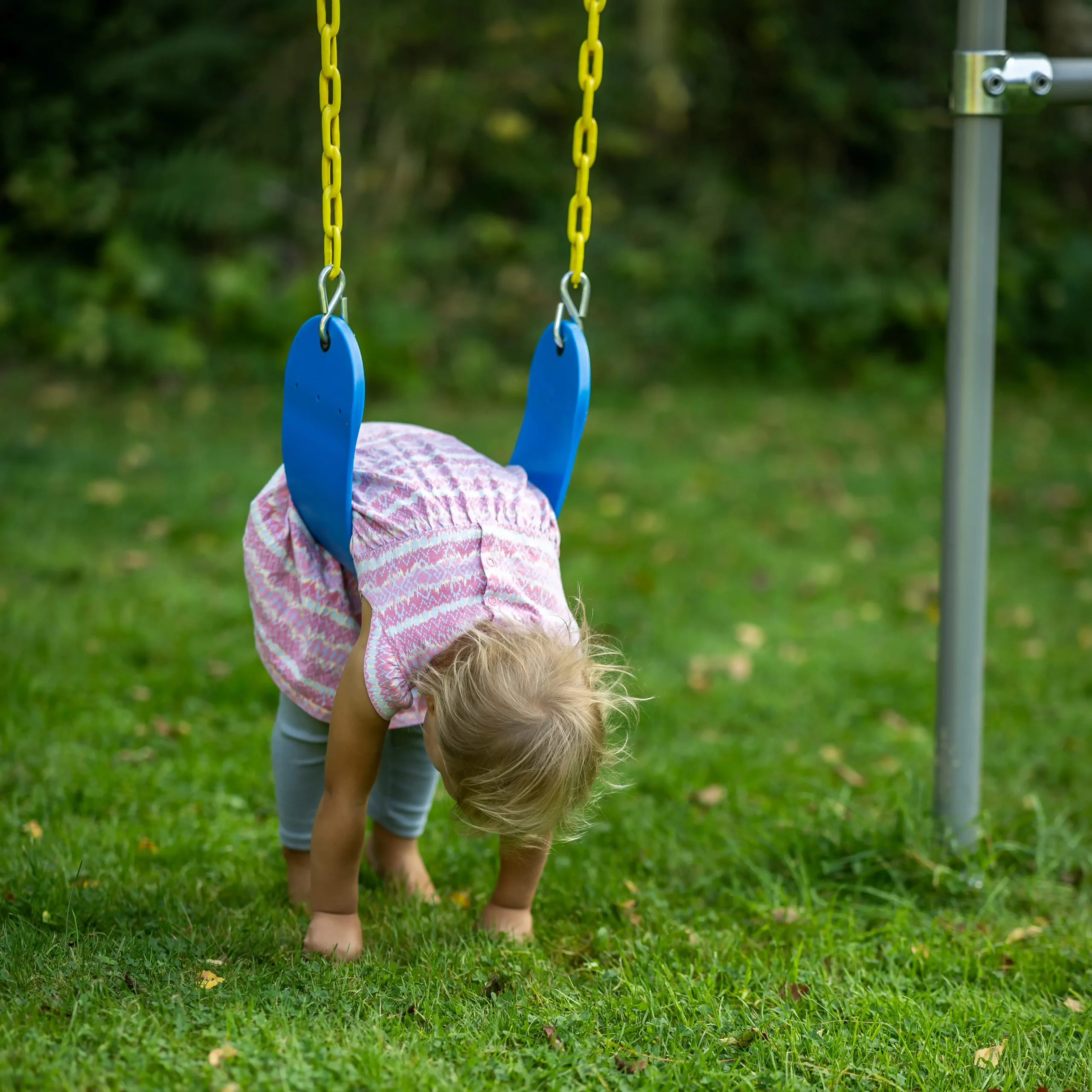 Kleinkind schwingt entspannt in einer flexiblen Kinderschaukel und bewegt sich sanft hin und her