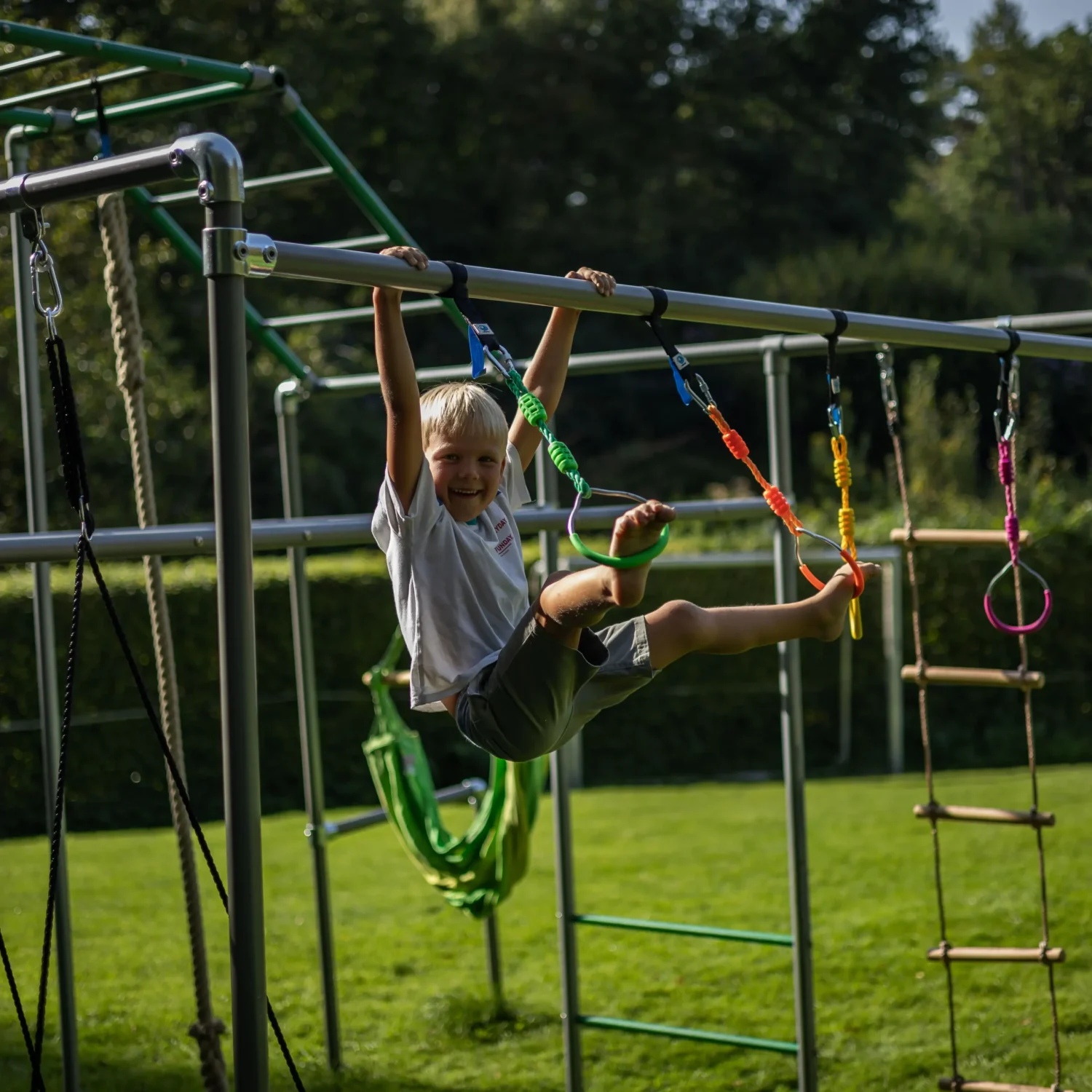 Kind klettert frei auf einem FOURACTION Klettergerüst im Garten