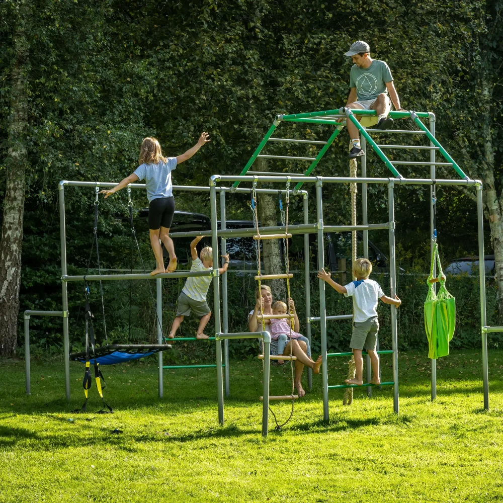 Kinder und Erwachsene nutzen gemeinsam ein Klettergerüst zum Balancieren, Schaukeln und Entspannen